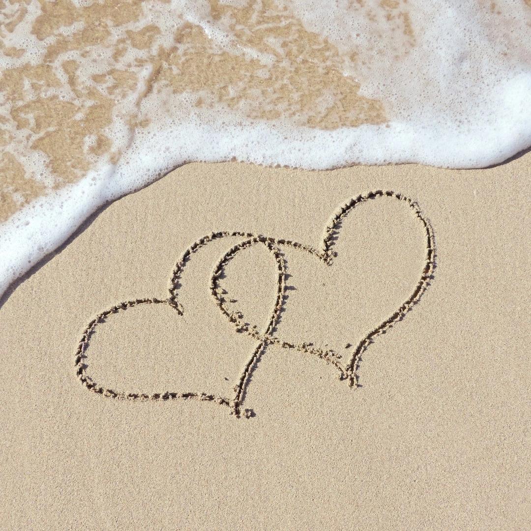 Coeur dessinés dans le sable sur la plage après une escapade romantique à l'hôtel en bord de mer San Lucianu 