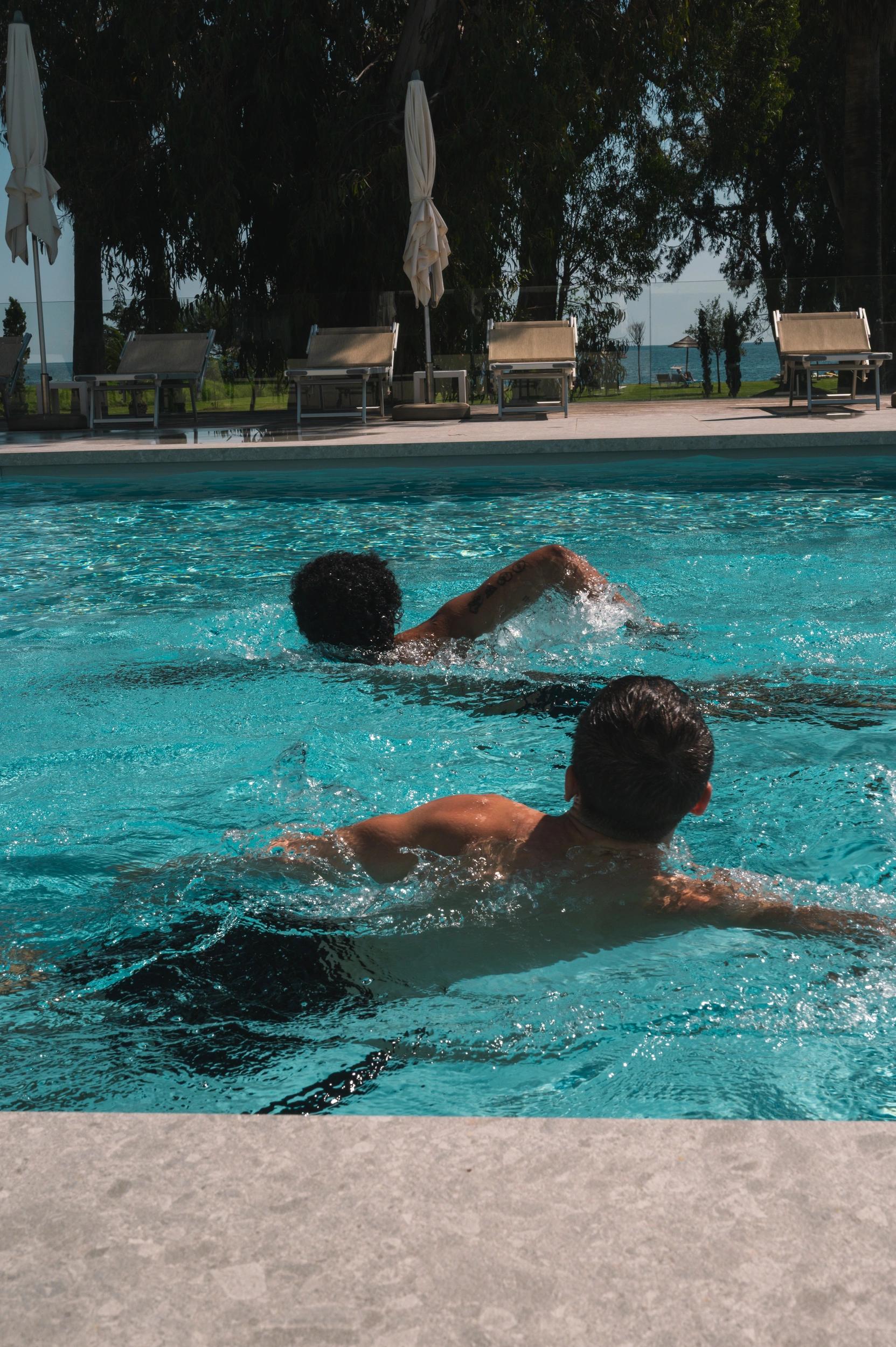 Deux personnes nageant dans la piscine extérieure de l'hôtel San Lucianu à Moriani plage 