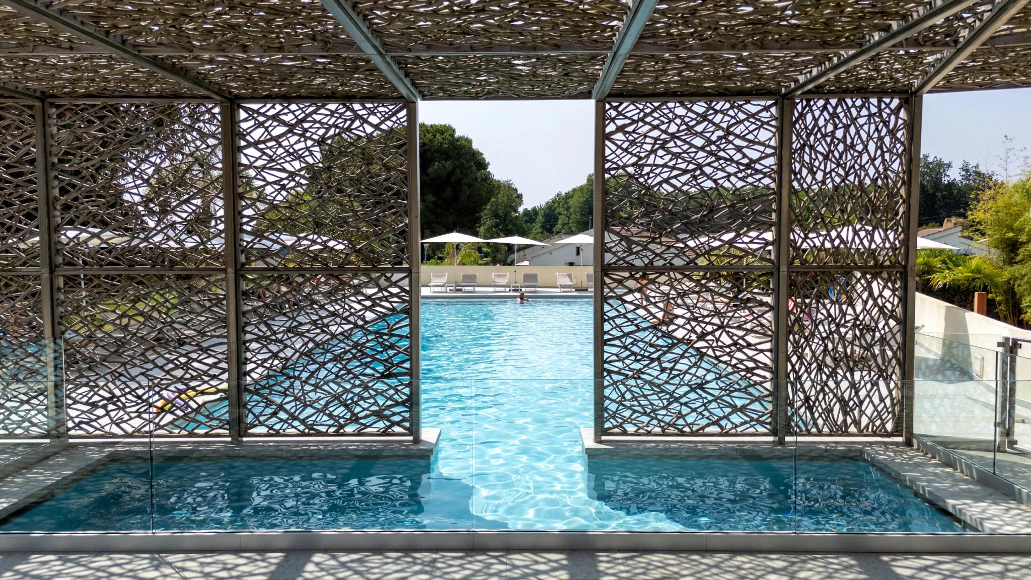 Piscine de l'hôtel San Lucianu à Moriani plage entourée d'arbres et de transats