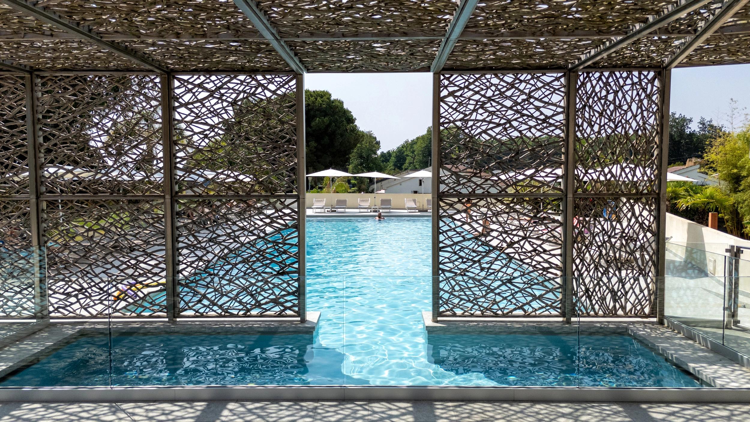 Piscine de l'hôtel San Lucianu à Moriani plage entourée d'arbres et de transats