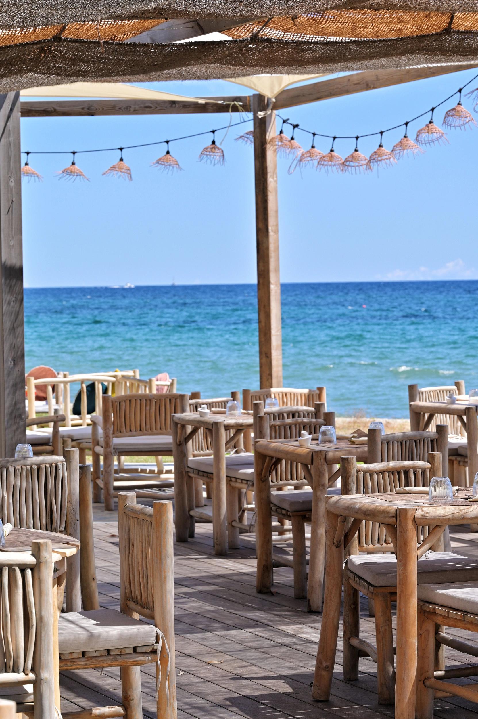 Tables en bois sur la terrasse de la paillotte de l'hôtel San Lucianu en Haute-Corse