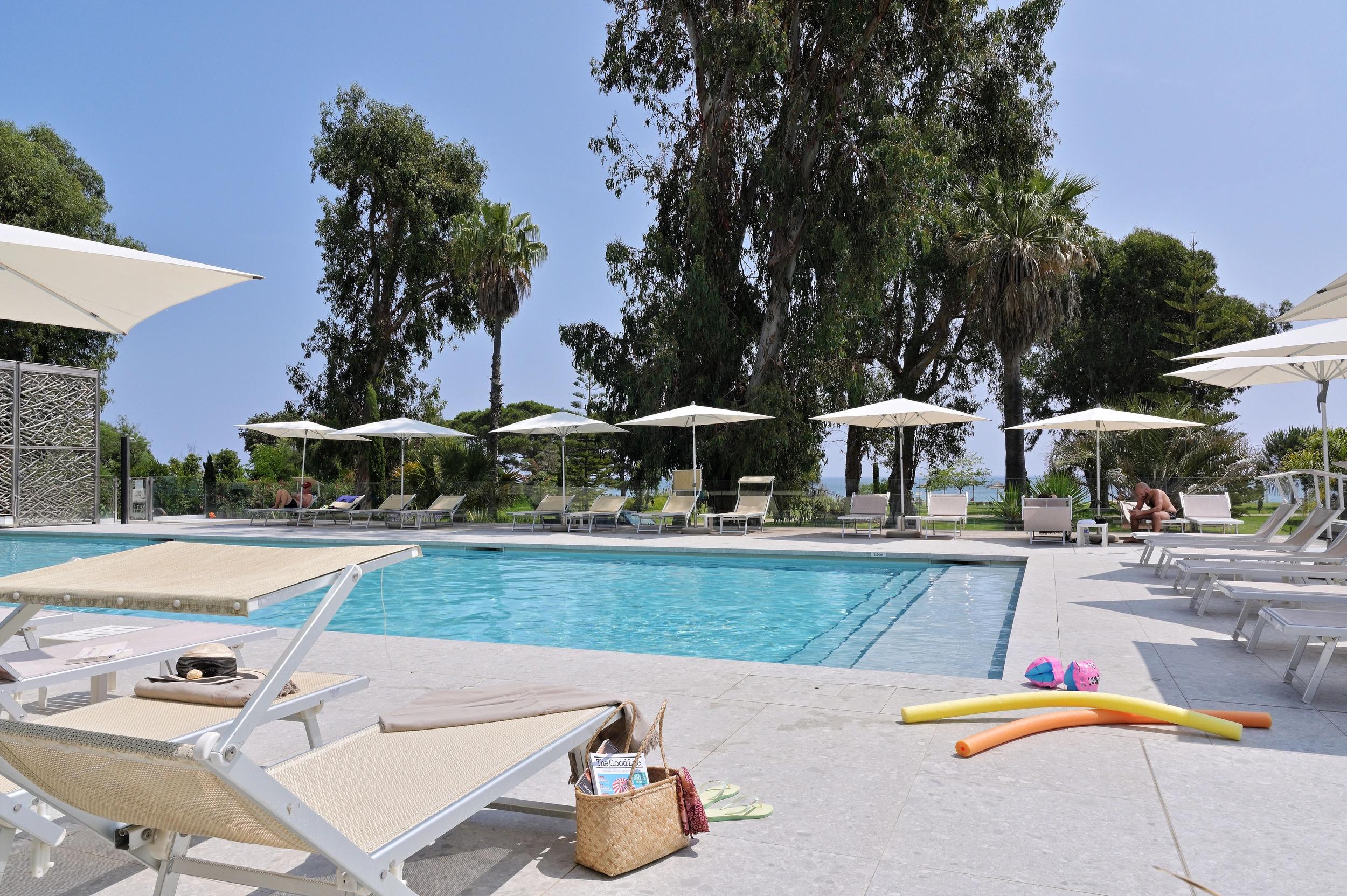 Piscine ensoleillée de l'hôtel 3 étoiles San Lucianu à Moriani plage entourée de transats