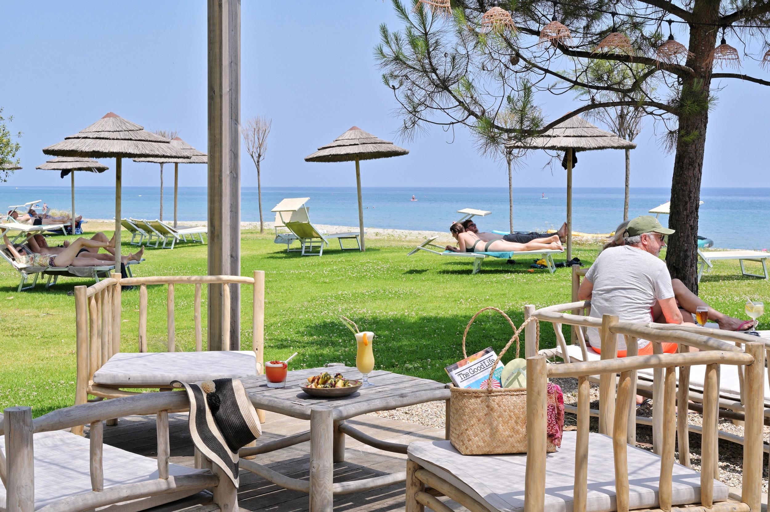 Espace détente avec transats et parasols face à la mer à l'hôtel 3 étoiles San Lucianu 